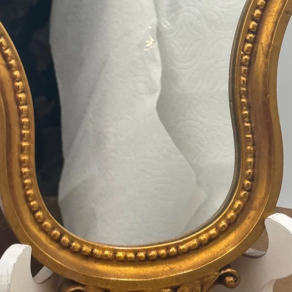 French-style ornate wall mirror, rococo or baroque decorative elements in a gil
